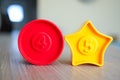Closeup shot of a red circle and yellow star shaped plastic toy with the numbers four and five