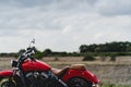 Closeup shot of a red motorcycle with a field in the blurry background