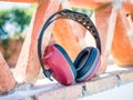 Closeup shot of red noise canceling construction headphones leaning on a patterned structure