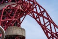 Closeup shot of red steel pipe tower design on a blue sky background