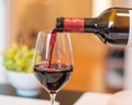 Closeup shot of a red wine pouring from a bottle to a glass Royalty Free Stock Photo