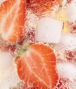 Closeup shot of a refreshing drink with a slice of strawberries and ice cubes Royalty Free Stock Photo