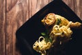 Closeup shot of a roasted chicken with Fettucine pasta on a black plate Royalty Free Stock Photo