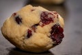 Closeup shot of a roll of raisins on a chocolate chip cookie dough on a smooth surface