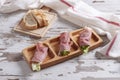 Closeup shot of rolled ham with lettuce filling with sliced toasted bread on a wooden platters