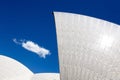 Closeup shot of the roof of Sydney Opera House under the blue sky with a cloud in Sydney, Australia