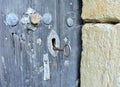 Closeup shot of a round iron key in the keyhole of an old wooden door Royalty Free Stock Photo