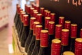 Closeup shot of rows of glass red wines with gold red caps on a liquor shelf