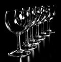 Closeup shot of rows of wine glasses isolated on a black background