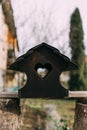 Closeup shot of a rustic birdhouse with a heart-shaped opening