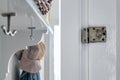 Closeup shot of a rusty metal door hinge on a white wooden door Royalty Free Stock Photo