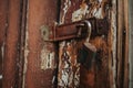 Closeup shot of a rusty padlock hanging on an old wooden door Royalty Free Stock Photo