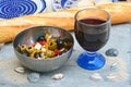 Closeup shot of a salad with olives and cheese in a bowl next to a baguette and a glass of wine Royalty Free Stock Photo