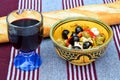 Closeup shot of a salad with olives and feta in a bowl next to a baguette and a glass of wine Royalty Free Stock Photo