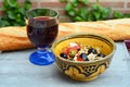 Closeup shot of a salad with olives and feta cheese in a bowl next to a baguette and wine glass Royalty Free Stock Photo