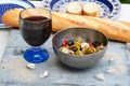 Closeup shot of a salad with olives and feta next to a baguette and a glass of wine Royalty Free Stock Photo