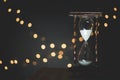 Closeup shot of a sand glass timer with blurred lights in the background Royalty Free Stock Photo