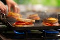 Closeup shot of sandwiches cooking on a grill attachment over a stove