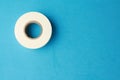 Closeup shot of a scotch tape roll isolated on a blue surface with copy space