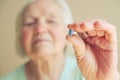 Closeup shot of a senior woman showing blue pill. Healthcare old people concept.