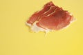 Closeup shot of serrano ham slices on a yellow background Royalty Free Stock Photo