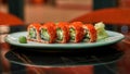 Closeup shot of set of red sushi rolls with caviar, seafood, wasabi and ginger laid out on a white plate on a table of Royalty Free Stock Photo