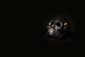 Closeup shot of a shiny skull with candlelight inside of it isolated on a dark background