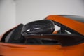 Closeup shot of a side mirror on an orange convertible sports car with white background Royalty Free Stock Photo