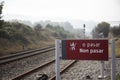 Closeup shot of a sign near railroads, translation: Do not pass Royalty Free Stock Photo