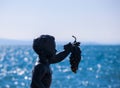 Closeup shot of a silhouette of a statue of a child holding grape