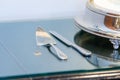 Closeup shot of a silver cake knife and a server on a glass table Royalty Free Stock Photo