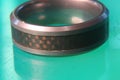 Closeup shot of a silver patterned ring on a green surface Royalty Free Stock Photo