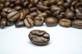 Closeup shot of a single brown coffee bean in the blurred background of the many other coffee beans Royalty Free Stock Photo