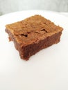 Closeup shot of a single slice of delicious brownie on a white plate