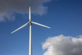 Closeup shot of a single windmill for electric power production with a cloudy sky behind Royalty Free Stock Photo