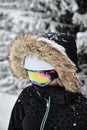 Closeup shot of a skier wearing fur hooded jacket and goggles at Alpe d Huez ski resort, France