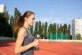 Closeup shot of slender fit girl doing exercises with the dumbbells at the stadium. Space for text Royalty Free Stock Photo