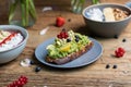 Closeup shot of a slice of brown bread with avocado pasta and a smoothie bowls Royalty Free Stock Photo