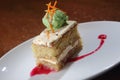 Closeup shot of a slice of carrot cake and a scoop of pistachio ice cream on a white plate Royalty Free Stock Photo