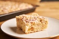 Closeup shot of a slice of a delicious apple pie on a plate on a wooden table