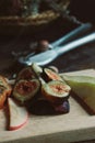 Closeup shot of slices of juicy ripe figs, pear and apple on the wooden tray Royalty Free Stock Photo