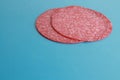 Closeup shot of slices of salami on a blue background