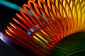 Closeup shot of a slinky rainbow spring toy on a black background Royalty Free Stock Photo