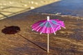 Closeup shot of a small cocktail umbrella on a wooden surface