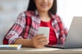 Closeup shot of smiling asian lady reading message on smartphone in office Royalty Free Stock Photo