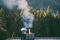 Closeup shot of the smoke coming out of chimney with the background of forest Royalty Free Stock Photo