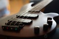 Closeup shot of a smooth body, pickups, bridge, knobs and strings of a bass guitar musical instrument with backlight Royalty Free Stock Photo