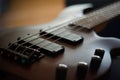 Closeup shot of a smooth body, pickups, bridge, knobs and strings of a bass guitar musical instrument with backlight Royalty Free Stock Photo