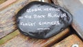 Closeup shot of smooth and shiny rock with text on a wooden surface