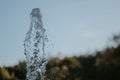 Closeup shot of splashing water in the air with trees on the background Royalty Free Stock Photo